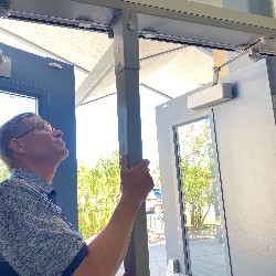 Tim Clark removes a barrier in a school doorframe to allow large cleaning equipment inside the building.